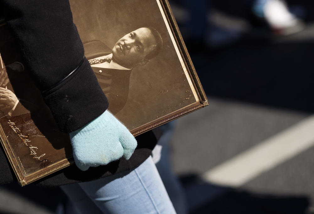 A marcher in Macon carries a framed photograph of Martin Luther King Jr.