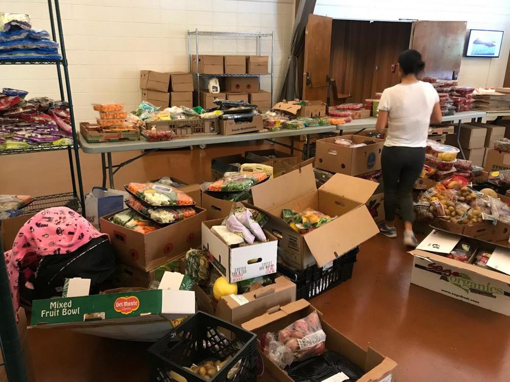 A volunteer at Malachi's Storehouse arranges produce for the 150 people who visit each Wednesday to get groceries.