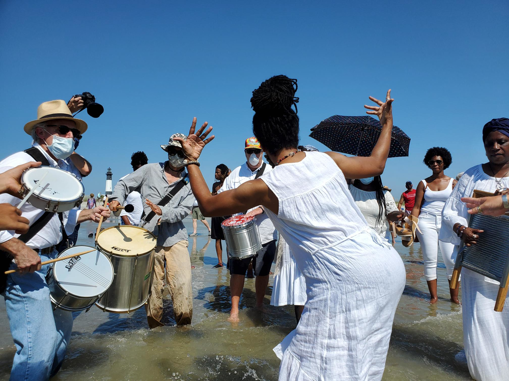 People dance, sing and play music in the shallows at Tybee Island during the annual Juneteenth wade-in.