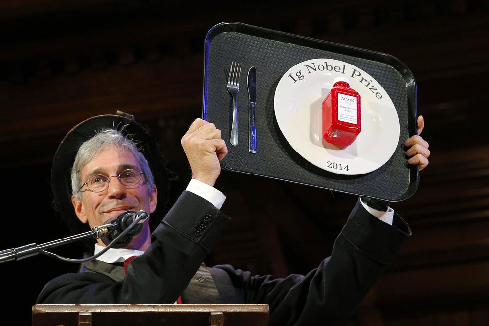 Ig Nobel Founder Marc Abrahams holds up an Ig Nobel Prize trophy. 