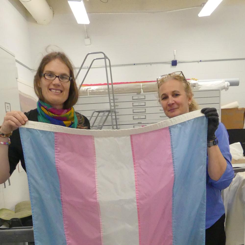 Helm's wife Darlene (left) holds the flag with a staff member at the Smithsonian, where the original flag is being kept.