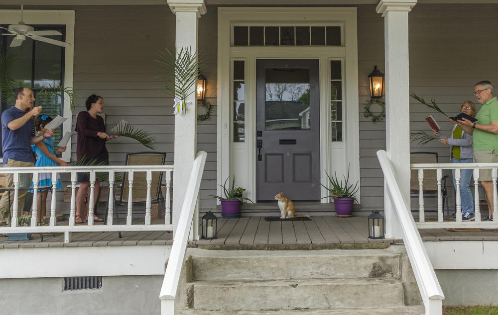 The Harpers, left, and the Lewises, right, sing Palm Sunday hymns together on the Lewis's Macon porch. 