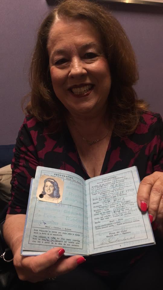 Carmen Bernal holds up her Cuban passport that she had when she arrived in the U.S. in 1961.