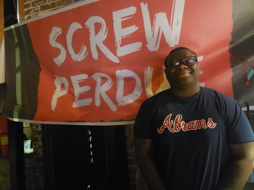 Darion Reed watches the Nov. 20, 2019, Democratic national debate from the Georgia Beer Garden in Atlanta. He says he wants to stay neutral but thinks Sens. Warren and Harris have had great moments.