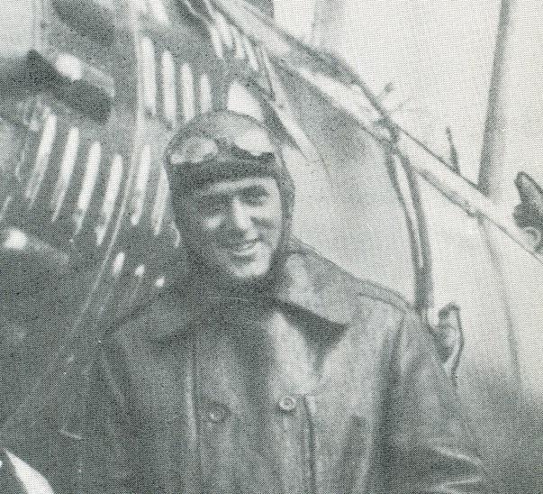 Roland Neel of Macon, Georgia in his flight outfit, standing in front of his plane [undated).