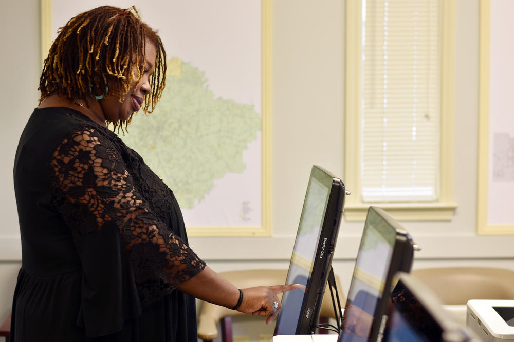 Henry County Elections Director Ameika Pitts casts a ballot in a mock election Wednesday, Feb. 26, 2020.