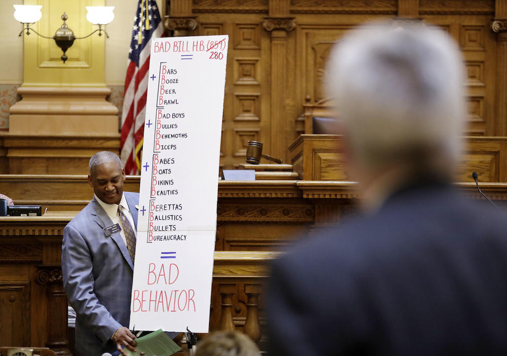 Georgia Sen. Emanuel Jones, D - Decatur, carries a poster board after speaking against a bill allowing concealed handguns on public college campuses as legislators debate the measure at the Capitol in Atlanta, Tuesday, March 28, 2017. 