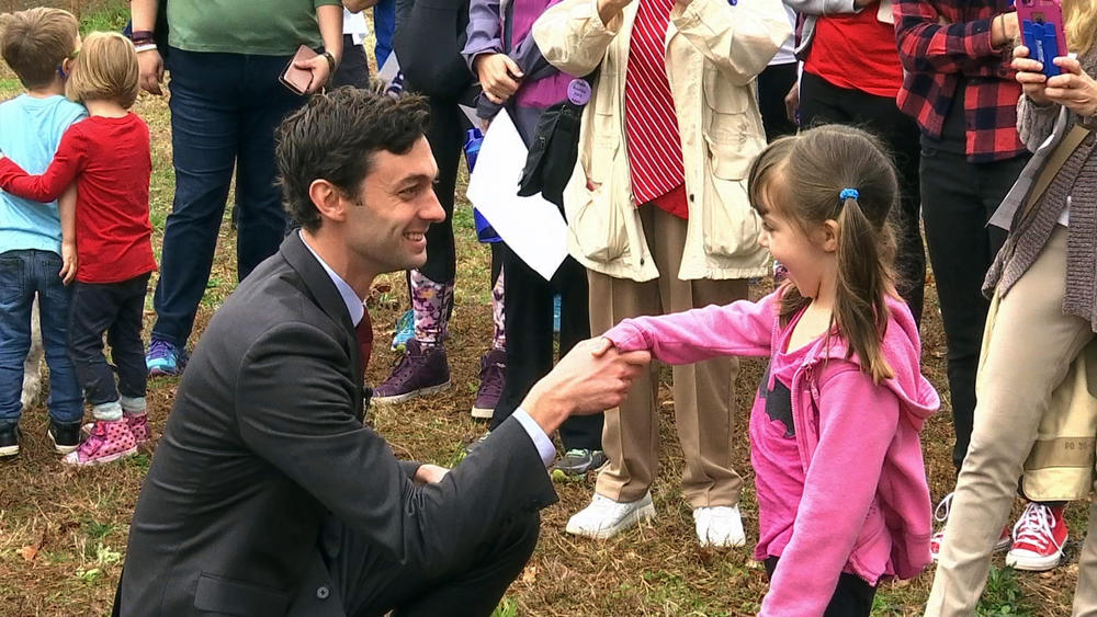 In a Monday, March 27, 2017 photo, Democratic congressional candidate Jon Ossoff is seen with supporters outside of the East Roswell Branch Library in Roswell, Ga., on the first day of early voting.