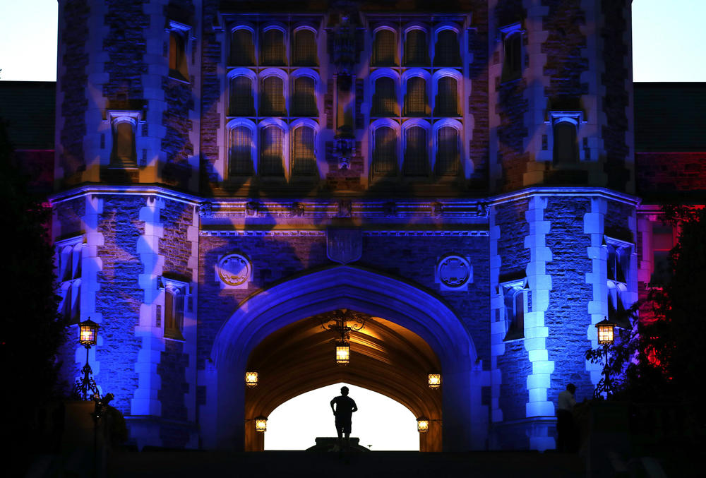 A man jogs up stairs to Brookings Hall, which is lit up in a patriotic theme, as preparations continue ahead of the second presidential debate at Washington University in St. Louis this Sunday.