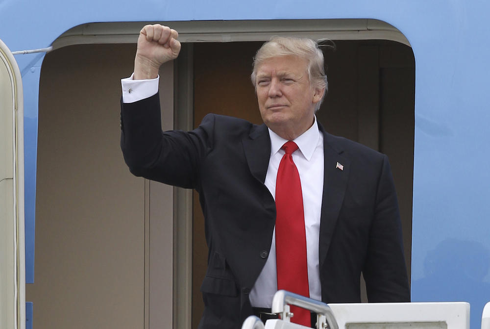 President Donald Trump gestures from the stairs of Air Force One upon his arrival at Palm Beach International Airport in West Palm Beach, Fla. Friday, March 3, 2017.