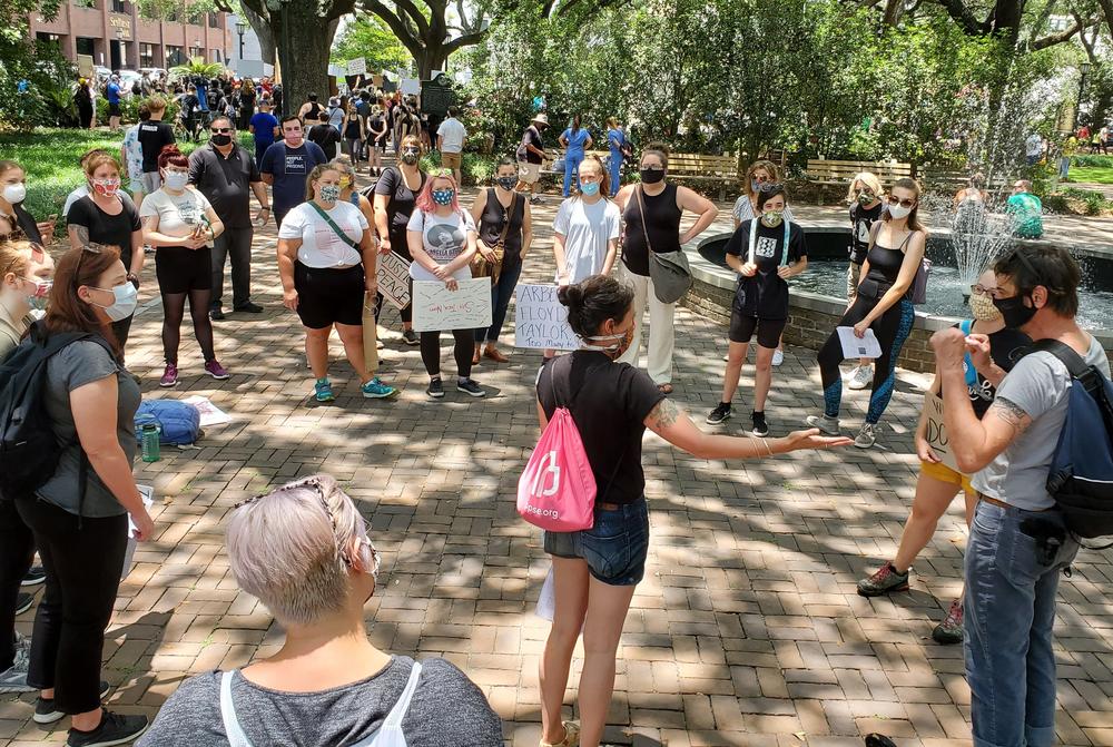 Activist Coco Papy (center) explains how to step in to keep black protesters safe if someone tries to incite violence.