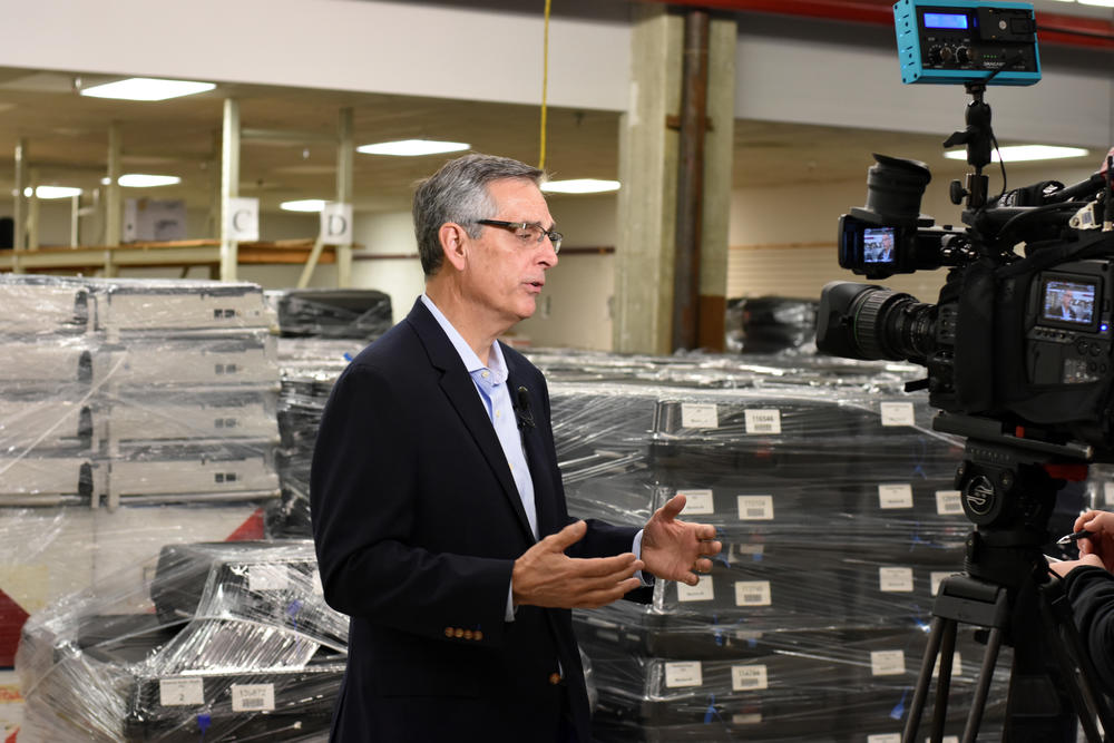Secretary of State Brad Raffensperger answers questions in a DeKalb County warehouse in December, 2019.