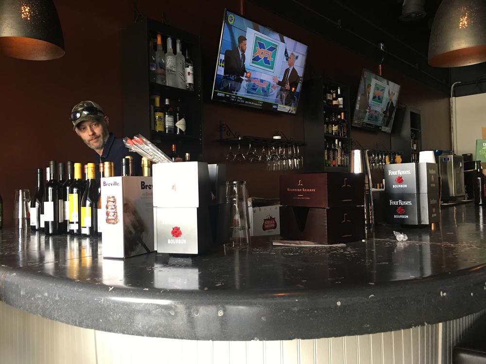 Miramar Raw Bar & Tapas bar manager Josh Howard stocks liquor at the new restaurant that is opening Feb. 13 on Forsyth Road in North Macon