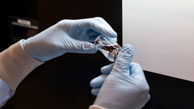 A lab technician visually inspects a filled vial of investigational coronavirus disease (COVID-19) treatment drug remdesivir at a Gilead Sciences facility in La Verne, California, March 11, 2020.