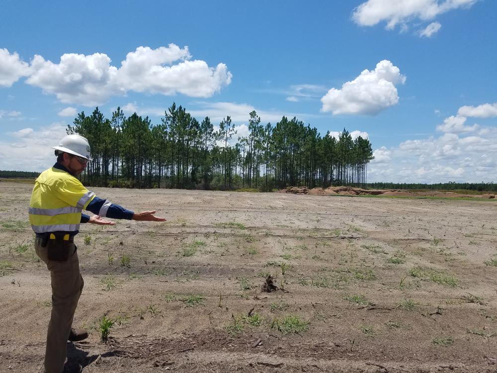 Jim Renner of Southern Ionics Minerals explains the post-mining reclamation process. This area has had its topsoil replaced and will be planted with loblolly and slash pine in the winter. In the distance is a wetland area the mine avoided.