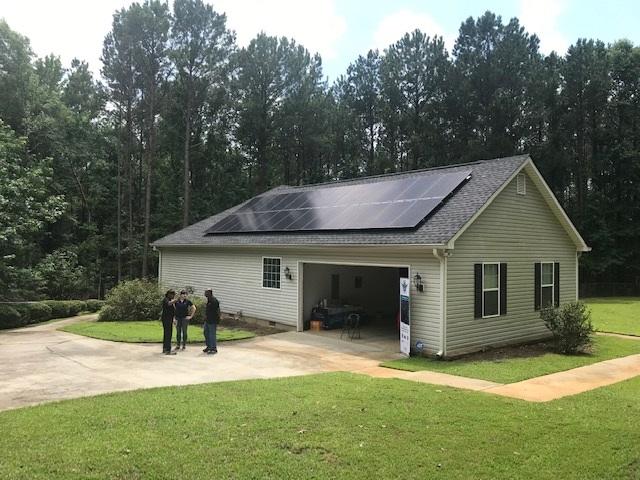 L-R Homeowner Eric Byas and Chaia Lews with Creative Solar talk to one of Byas' neighbors about residential solar power.