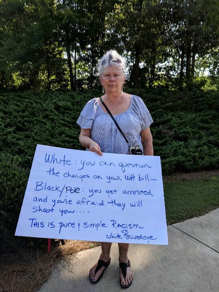 Samantha Claair holds a sign outside Waffle House headquarters in Norcross Friday June 15 in support of activists' cry for justice for Anthony Wall and Chikesia Clemons, both of whom were arrested after employees called police on them.