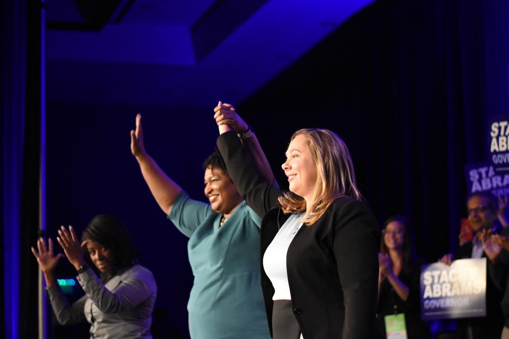 The Democratic Party of Georgia's nominee for governor Stacey Abrams (left) and lieutenant governor nominee Sarah Riggs Amico take the stage in Atlanta at the party's state convention Saturday, Aug. 25.
