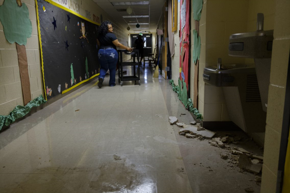 Pre-kindergarten teacher Jessica Beard walks past storm damage at Potter Street Elementary.