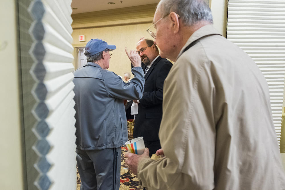 Tom Rockenbach, center,  executive director of the Carlyle Place senior living facility in Macon, Georgia, talks with a resident before beginning the weekly community meeting he runs for residents. 