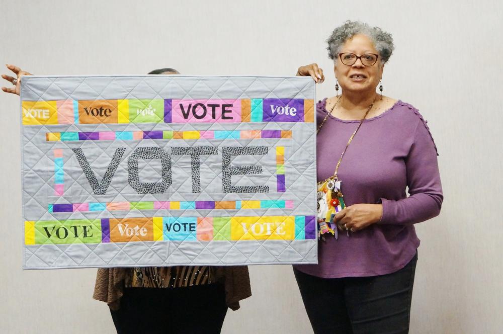 Quilter Nancy Franklin showcases her latest piece during the February meeting of the Brown Sugar Stitchers Quilt Guild in Decatur