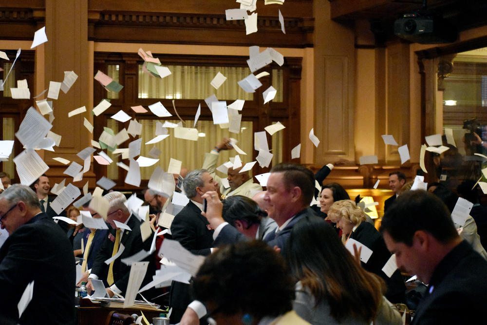 Members of the House toss bills into the air as the clock strikes midnight and the legislature adjourns Sine Die ending the 2019 legislative session. 