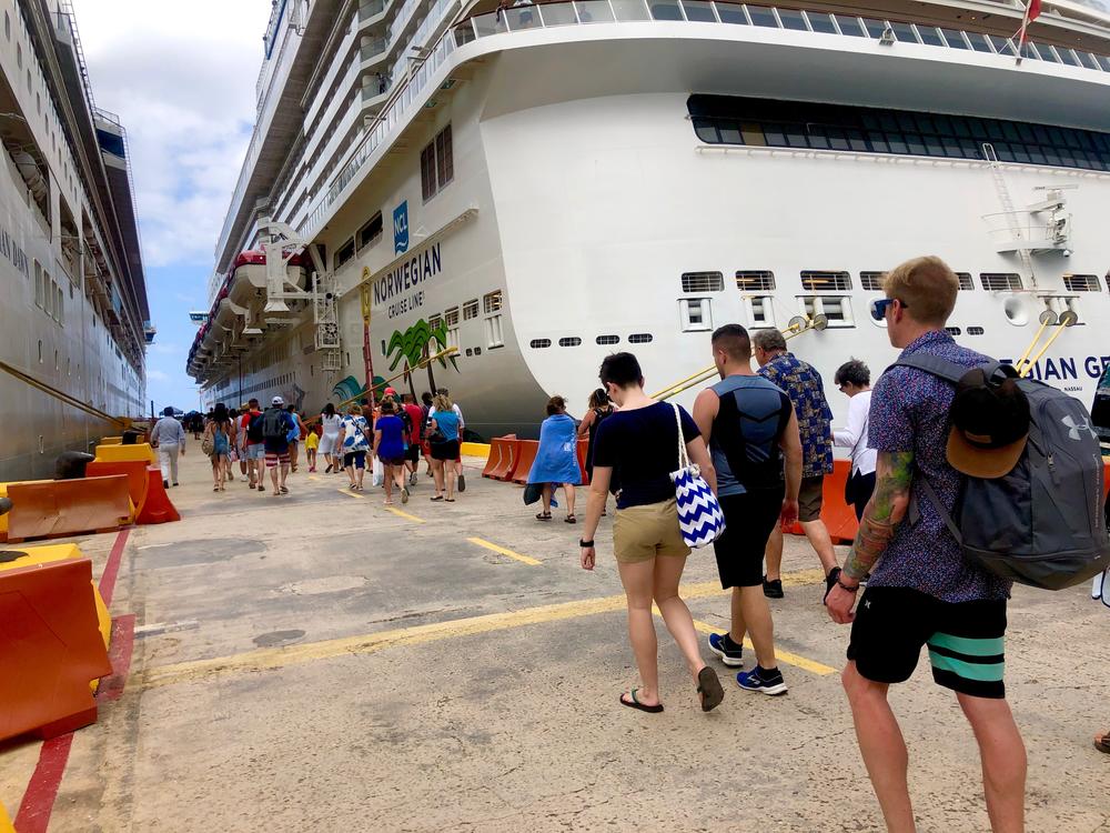 Passengers line up to board a Norwegian Cruise ship.  