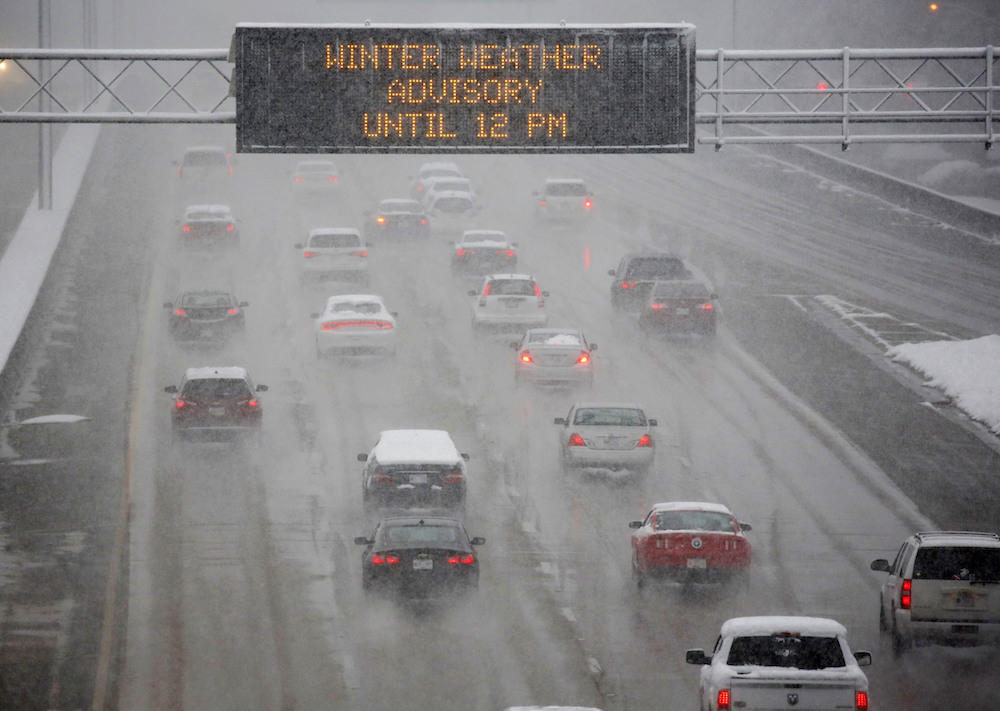 A heavy morning snow falls in Jackson, Miss., Friday, Dec. 8, 2017, as an electronic sign posts a winter weather advisory for drivers along I-55. The forecast called for a wintry mix of precipitation across several Deep South states. 