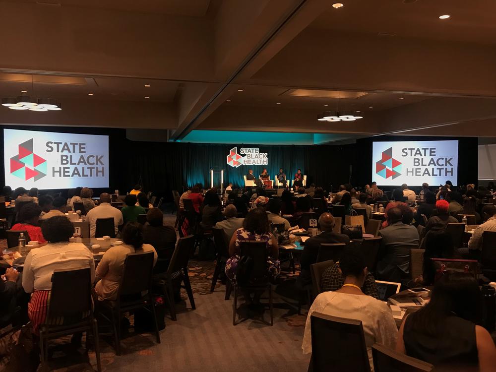 People listen to a panel on the first day of the State of Black Health conference. 