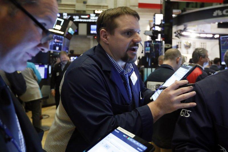 Trader Michael Milano, center, works on the floor of the New York Stock Exchange, Friday, March 6, 2020. 