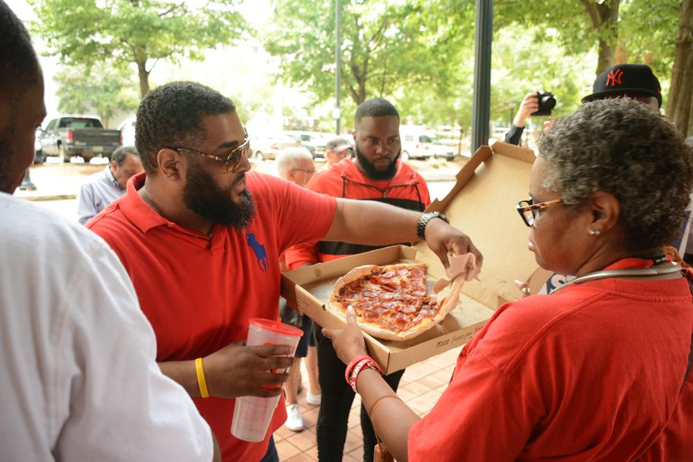 Workers eat pizza on day five of their strike. The food was gifted by Sarah Riggs Amico, who announced her candidacy for U.S. Senate on Tuesday.