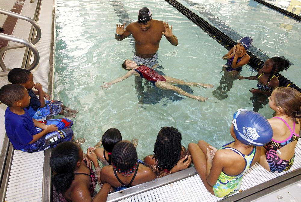 USA Swimming, Olympic Gold Medalist Cullen Jones, center, gives area children a swimming lesson at Centenary College in Shreveport La.