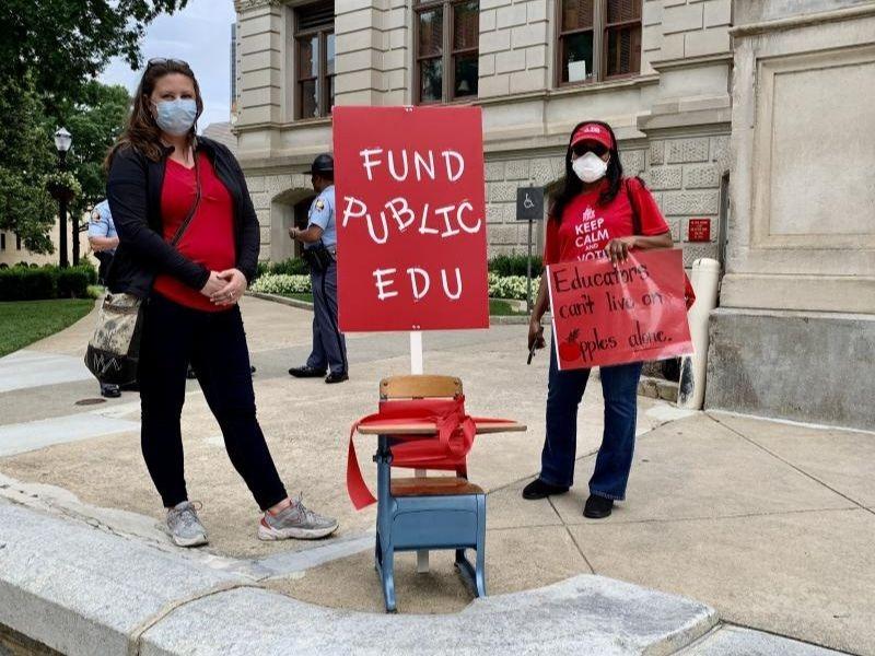 Teachers stand in from of the Capitol to talk to lawmakers about proposed budget cuts to education.