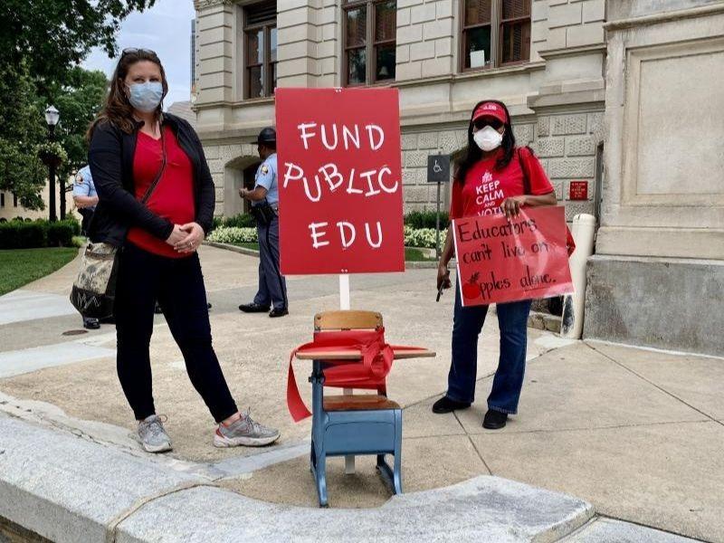 Teachers stand in from of the Capitol to talk to lawmakers about proposed budget cuts to education.