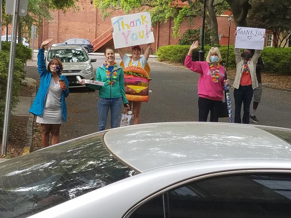A group gathered outside Emmaus House with donuts and 
