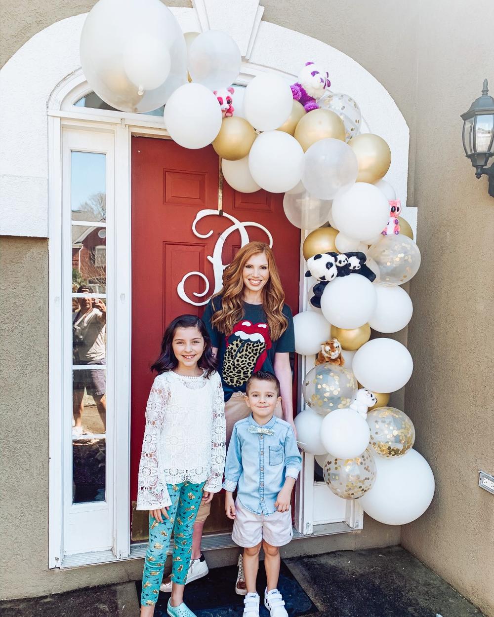 A family poses in front of their zoo-themed door to help bring happiness to fellow neighbors.