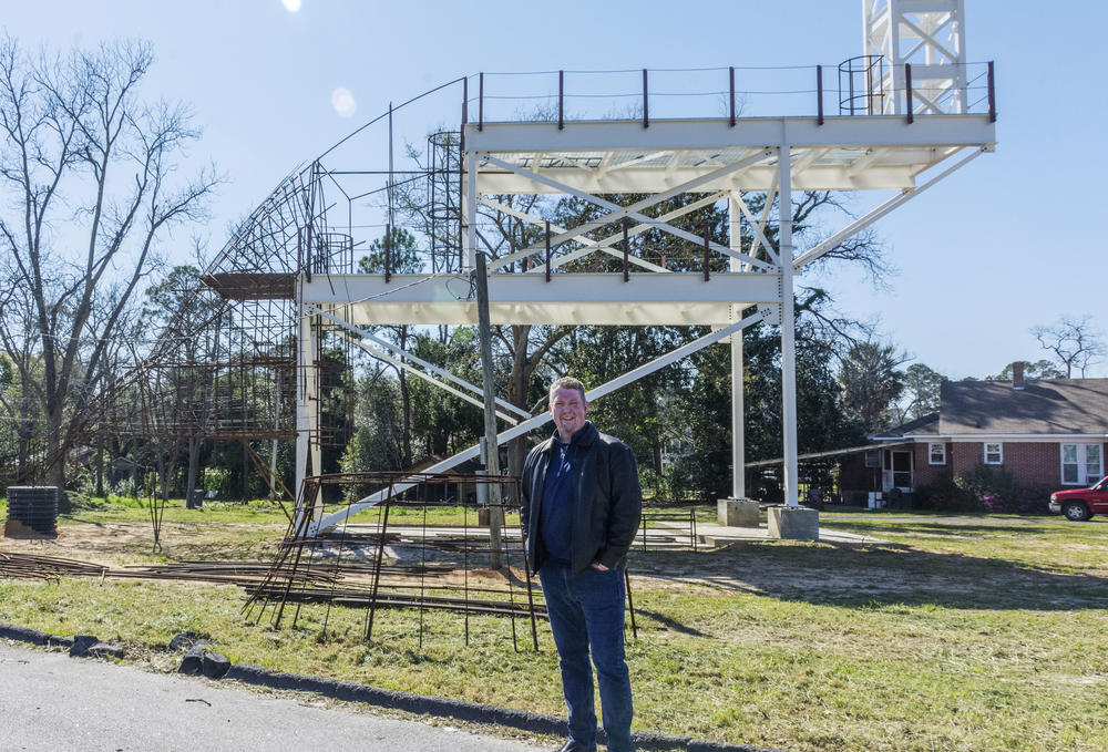 Mayor Jim Puckett stands in front of the frame of the topiary.