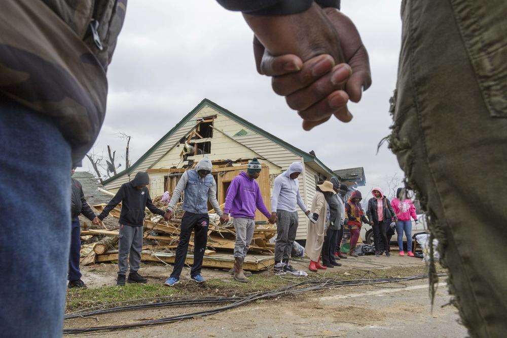 Residents of Talbotton, Ga. pray together outside a home destroyed by a tornado the day after storms battered Alabama and Georgia. 
