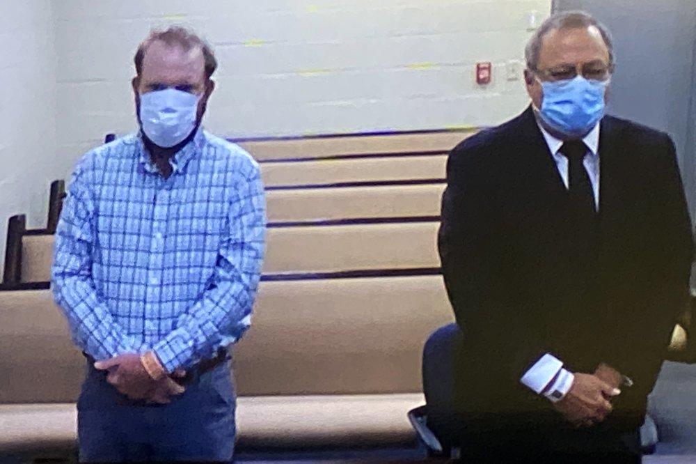 In this image made from video, Travis McMichael, left, and Greg McMichael listen to a preliminary hearing via a court video feed, Thursday, June 4, 2020, while inside the Glynn County jail, in Brunswick, Georgia.