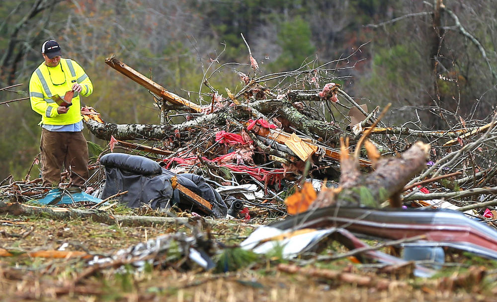 Bob Wright looks for personal belongings after a suspected tornado ripped through the town of Rosalie, killing three of his brother's family members, Wednesday, Nov. 30, 2016, in Rosalie, Ala. 