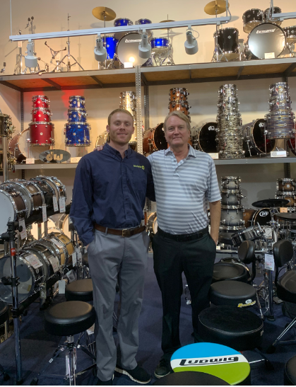 Zack Stanton (left) stands with father Kenny Stanton in the drum section of the Cobb Parkway Ken Stanton Music store. 