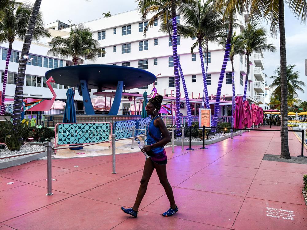 A woman walks past a closed restaurant this week in Miami Beach, Fla., during the coronavirus pandemic.