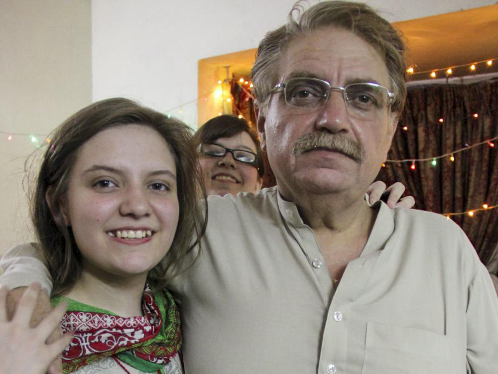 Idris Khattak disappeared in November. He is pictured with daughters Talia Khan and Shumaisa (in the background), on July 29, 2015, in Islamabad.