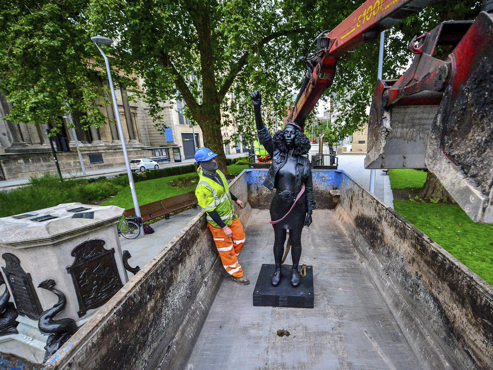 Contractors on Thursday remove Marc Quinn's statue, <em>A Surge of Power (Jen Reid) 2020</em>, after its temporary stint atop the plinth dedicated to slave trader Edward Colston in Bristol. Officials in the British city said the sculpture had been set up without their permission.