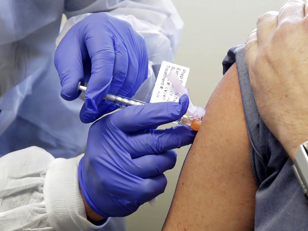 A volunteer receives a shot in a clinical trial for a potential coronavirus vaccine. U.S. intelligence officials say Russian hackers are attempting to break into U.S. health care organizations working on a vaccine.