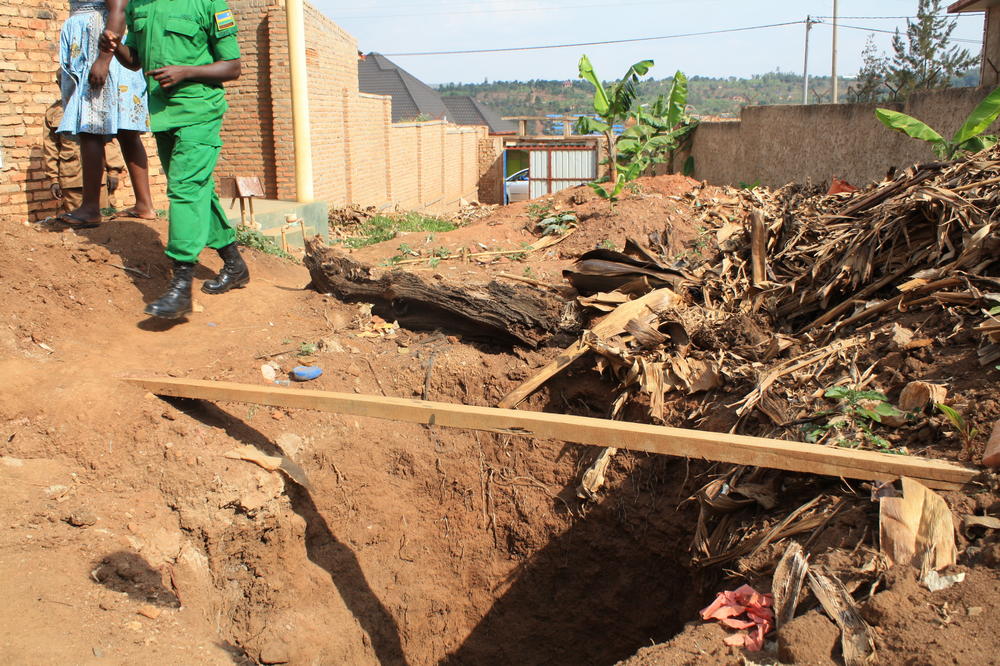 A makeshift bridge stretches across a deep mass grave. The <em>génocidaires</em> who lived in this house dug graves like this to hide the bodies of executed Tutsis.