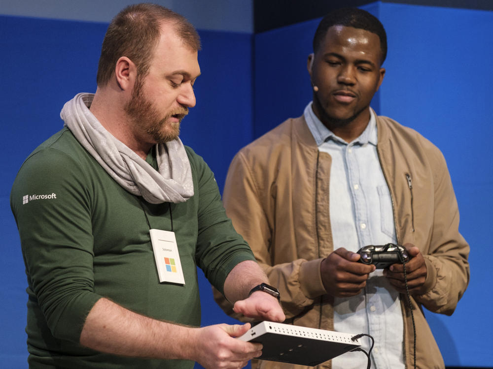 Microsoft's Solomon Romney, who has a partial hand, demonstrates the Xbox adaptive controller at a 2018 shareholders meeting.