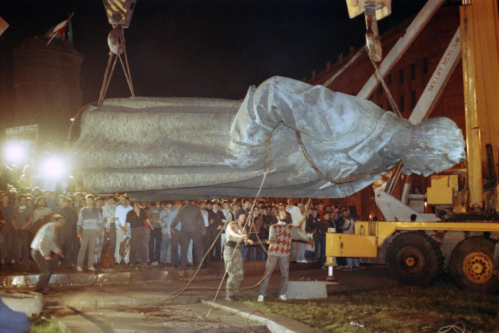 The U.S. isn't the only country where statues of controversial historical figures have been swept aside by protesters seeking a clean break with the past. Above, workers load a statue of KGB founder Felix Dzerzhinsky on a flatbed truck after it was toppled in Moscow on Aug. 23, 1991.
