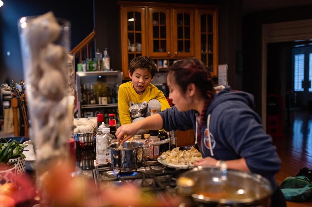Thu drops in dumplings for Lunar New Year celebrations as Hayle checks on the pot of boiling water on Jan. 26, 2020.
