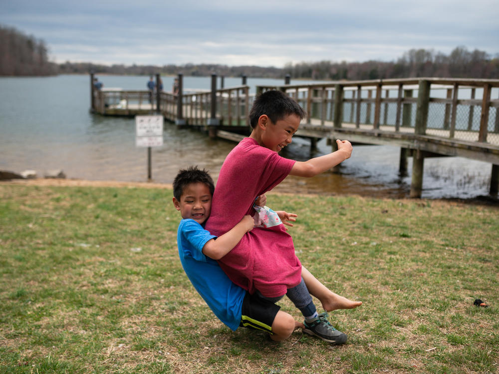 Hayle tackles Henry during a game of football Black Hill Regional Park in Boyds, Md., on April 7, 2019.